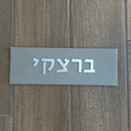 A design sign for a door made of clean concrete in gray with silver lettering - Israel series