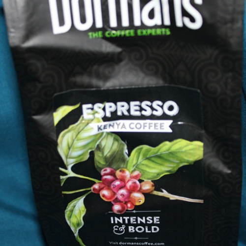 Close-up espresso coffee package with Kenyan coffee cherries and bold roast branding