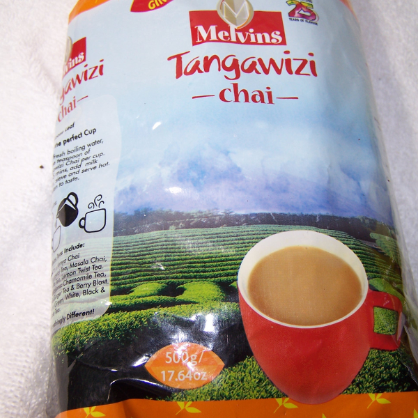Melvins Tangawizi Chai 500g Kenyan ginger black tea bag with brewed spiced chai cup on tea farm background